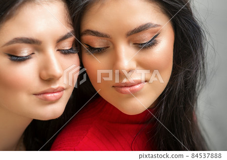 Portrait of young beautiful two women with long lashes and closed eyes after eyelash extensions. Portrait of young beautiful two women with long lashes and closed eyes after eyelash extensions. 84537888