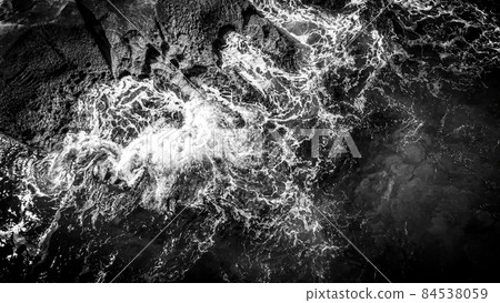 Wonderful turqouise blue ocean water hitting against the rocks - top down view 84538059