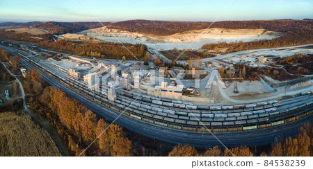 Aerial view of cargo train loaded with crushed sandstone materials at mine factory. Railway transportation of open pit mining ore Aerial view of cargo train loaded with crushed sandstone materials at mine factory. Railway transportation of open pit mining ore 84538239