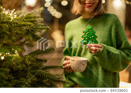 Woman holds gingerbread in a form of Christmas tree 84538601