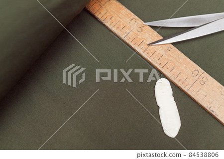 tailor marks up textile using soap and wooden ruler on pattern cutting tailor marks up textile using soap and wooden ruler on pattern cutting 84538806