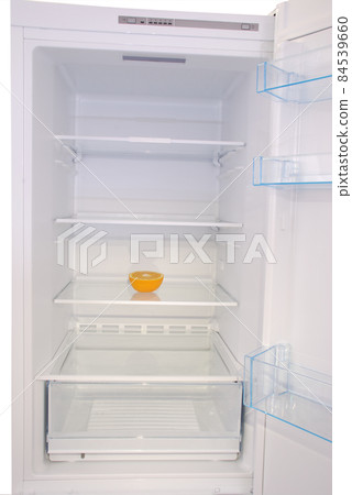 One orange in open empty refrigerator. 84539660