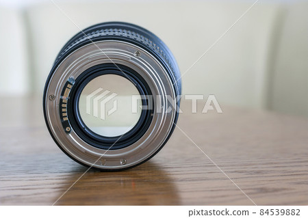 Professional Photography Equipment, Photographer Work Kit. Close-up macro shot of photo camera objective lens on wooden table. Shallow DOF Professional Photography Equipment, Photographer Work Kit. Close-up macro shot of photo camera objective lens on wooden table. Shallow DOF 84539882