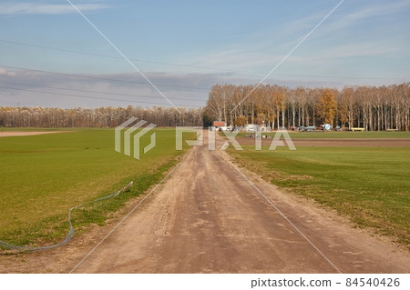 Agircutural field with dirt road Agircutural field with dirt road 84540426