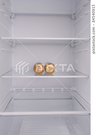 Two metal beer cans inside in empty clean refrigerator 84540915