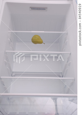 One pear in open empty refrigerator. 84540919