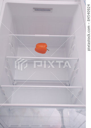One pepper in open empty refrigerator. 84540924