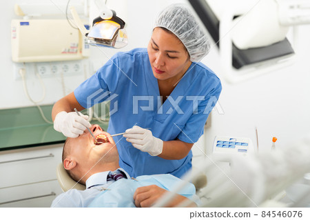 Dentist professional filling teeth for man patient sitting in chair Dentist professional filling teeth for man patient sitting in chair 84546076