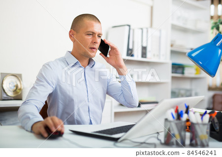 Businessman solving business issues by phone in office Businessman solving business issues by phone in office 84546241