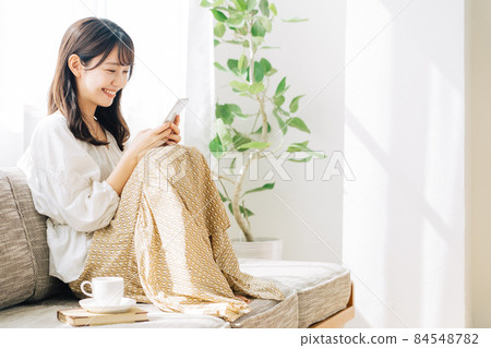 坐沙發和看智能手機的婦女 84548782