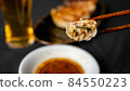 A photo of dumplings lifted with chopsticks showing a cross section 84550223