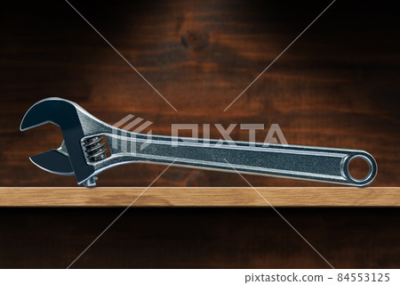 Modern Stainless Steel Adjustable Wrench on a Wooden Shelf Modern Stainless Steel Adjustable Wrench on a Wooden Shelf 84553125