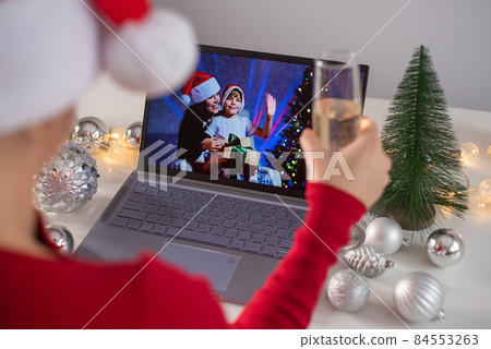 Caucasian woman calls family online on laptop and wishes a Merry Christmas. Remote meeting of the new year 84553263