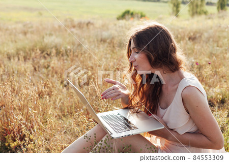 beautiful woman working on laptop remotely on the street beautiful woman working on laptop remotely on the street 84553309