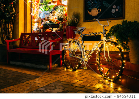 A bicycle decorated for the Christmas holidays on a night street. A bicycle decorated for the Christmas holidays on a night street. 84554311