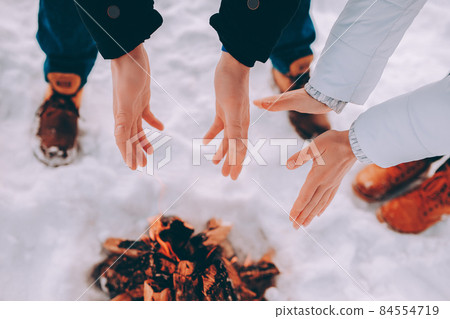 Man and woman warm their hands near fire. winter theme 84554719