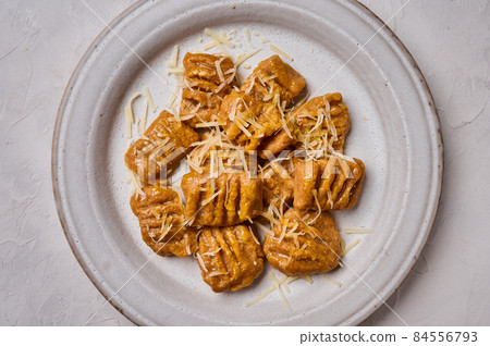 Macro flat lay Italian gnocchi from whole grain flour, baked pumpkin puree and parmesan 84556793