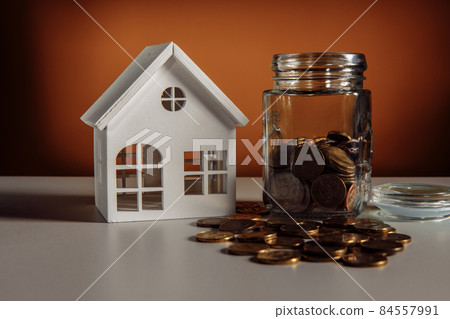 Model of house and glass jar with coins, financial and mortgage concept 84557991