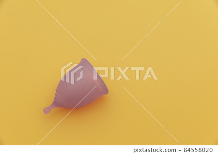 Reusable pastel purple menstrual cup on a yellow background with copy space. Women's hygiene, menstruation, critical days Reusable pastel purple menstrual cup on a yellow background with copy space. Women's hygiene, menstruation, critical days 84558020