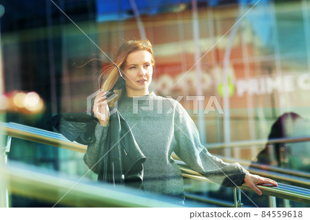 young blond slavic woman with long hair street portrait with glasses on shaping mall background 84559618