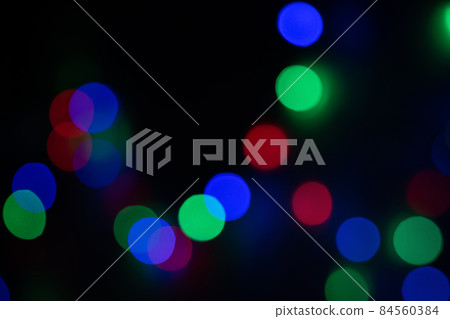 Defocused bokeh lights on black background, an abstract naturally blurred backdrop for Christmas eve or birthday party. Festive light texture. Colorful garland in blur. Overlay effect for design Defocused bokeh lights on black background, an abstract naturally blurred backdrop for Christmas eve or birthday party. Festive light texture. Colorful garland in blur. Overlay effect for design 84560384