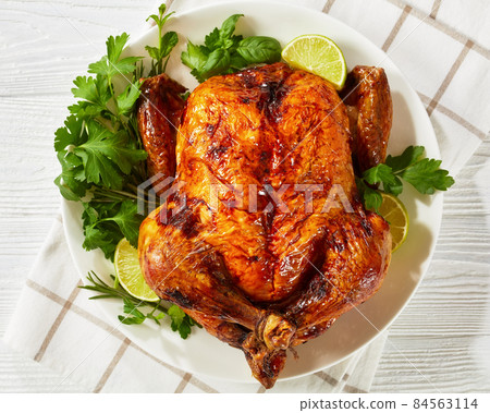 whole roast chicken, turkey on a plate with greens whole roast chicken, turkey on a plate with greens 84563114