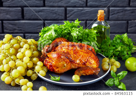 roast chicken on a plate with grapes and greens roast chicken on a plate with grapes and greens 84563115