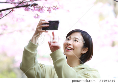 Woman taking pictures with a smartphone 84564845