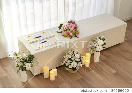 Wooden casket with a bouquet on the casket Home cremation, direct funeral, simple funeral image 84566060