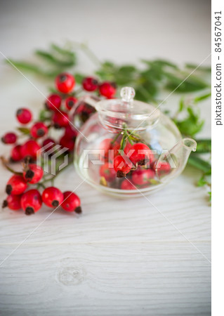 ripe red rose hips on a wooden table ripe red rose hips on a wooden table 84567041