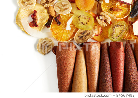 Neatly stacked fruit lozenge different colors and nuts.  84567492