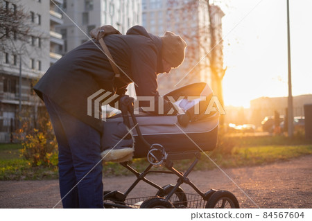 Happy young father with pram during the walk in nature 84567604