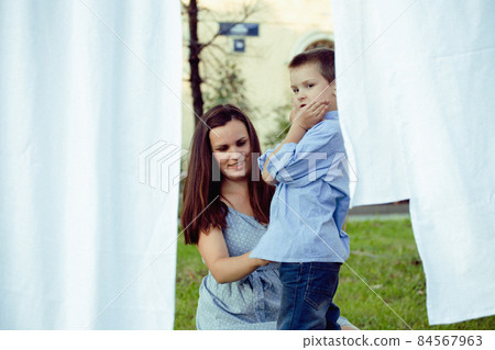 happy family making laundry outside, children helping 84567963