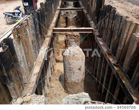 MALACCA, MALAYSIA -SEPTEMBER 25, 2015: Temporary steel sheet retaining wall using sheet pile cofferdam method holding outside soil from collaps into pile pits. MALACCA, MALAYSIA -SEPTEMBER 25, 2015: Temporary steel sheet retaining wall using sheet pile cofferdam method holding outside soil from collaps into pile pits. 84569708