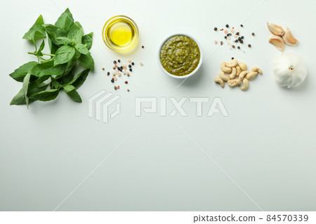 Pesto sauce and ingredients on white background Pesto sauce and ingredients on white background 84570339
