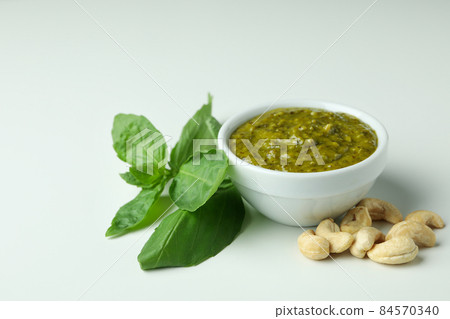 Pesto sauce and ingredients on white background Pesto sauce and ingredients on white background 84570340
