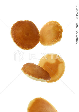 Tasty falling pancakes isolated on white background 84570569