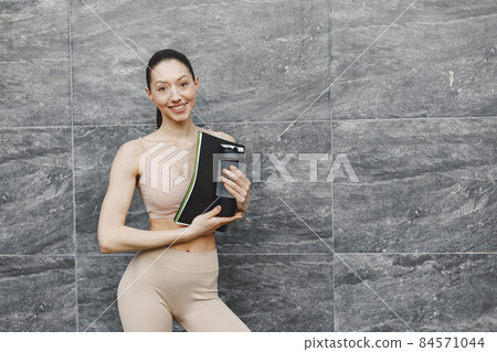 Woman practicing advanced yoga against a dark urban wall 84571044