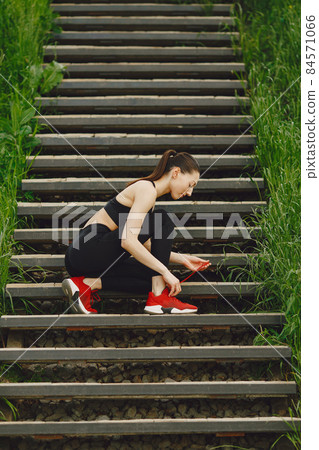 Woman in a black spoerswear standing on a stairs 84571066