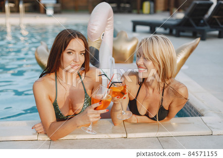 Women in swimsuit resting in a pool Women in swimsuit resting in a pool 84571155