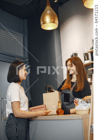 Woman pays for her purchase at the checkout. 84571215