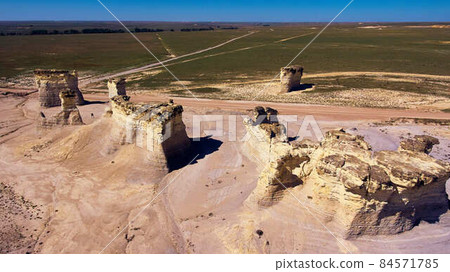 Aerial view of desert road with pillars of white rock in unusual formations Aerial view of desert road with pillars of white rock in unusual formations 84571785