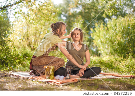 Proffesional masseuse applies her massage skills on her client in the daylight. Proffesional masseuse applies her massage skills on her client in the daylight. 84572239