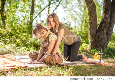 Massage expert demonstrates refreshing massaging methods out in the forest. Massage expert demonstrates refreshing massaging methods out in the forest. 84572267
