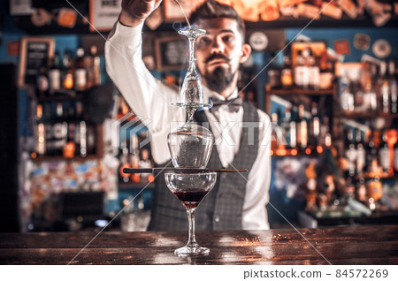 Confident bartending creates a cocktail at the bar counter Confident bartending creates a cocktail at the bar counter 84572269
