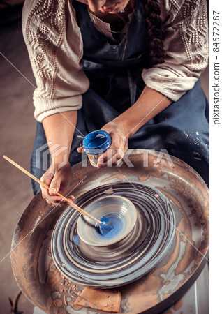 Handicraftsman master working on potter's wheel with raw clay with hands. Handcraft. Close-up. Handicraftsman master working on potter's wheel with raw clay with hands. Handcraft. Close-up. 84572287