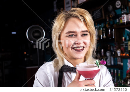 Confident woman bartending is pouring a drink in the bar 84572330