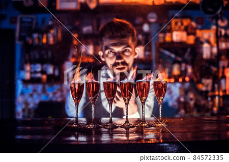 Barman mixes a cocktail at the bar Barman mixes a cocktail at the bar 84572335