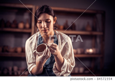 Stylish craftsmen enjoying pottery art and production process. Concept for woman in freelance, business, hobby. Stylish craftsmen enjoying pottery art and production process. Concept for woman in freelance, business, hobby. 84572354