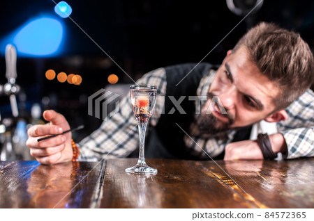 Barman formulates a cocktail in the brasserie Barman formulates a cocktail in the brasserie 84572365